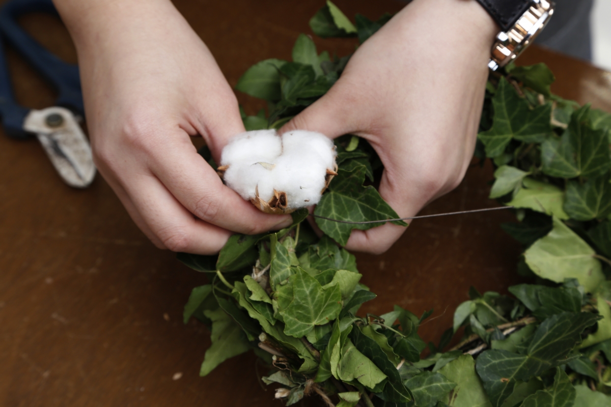 step 4_將木棉花的枝節插在長春藤的縫隙,再用餘下鐵線頭捲實藤圈。