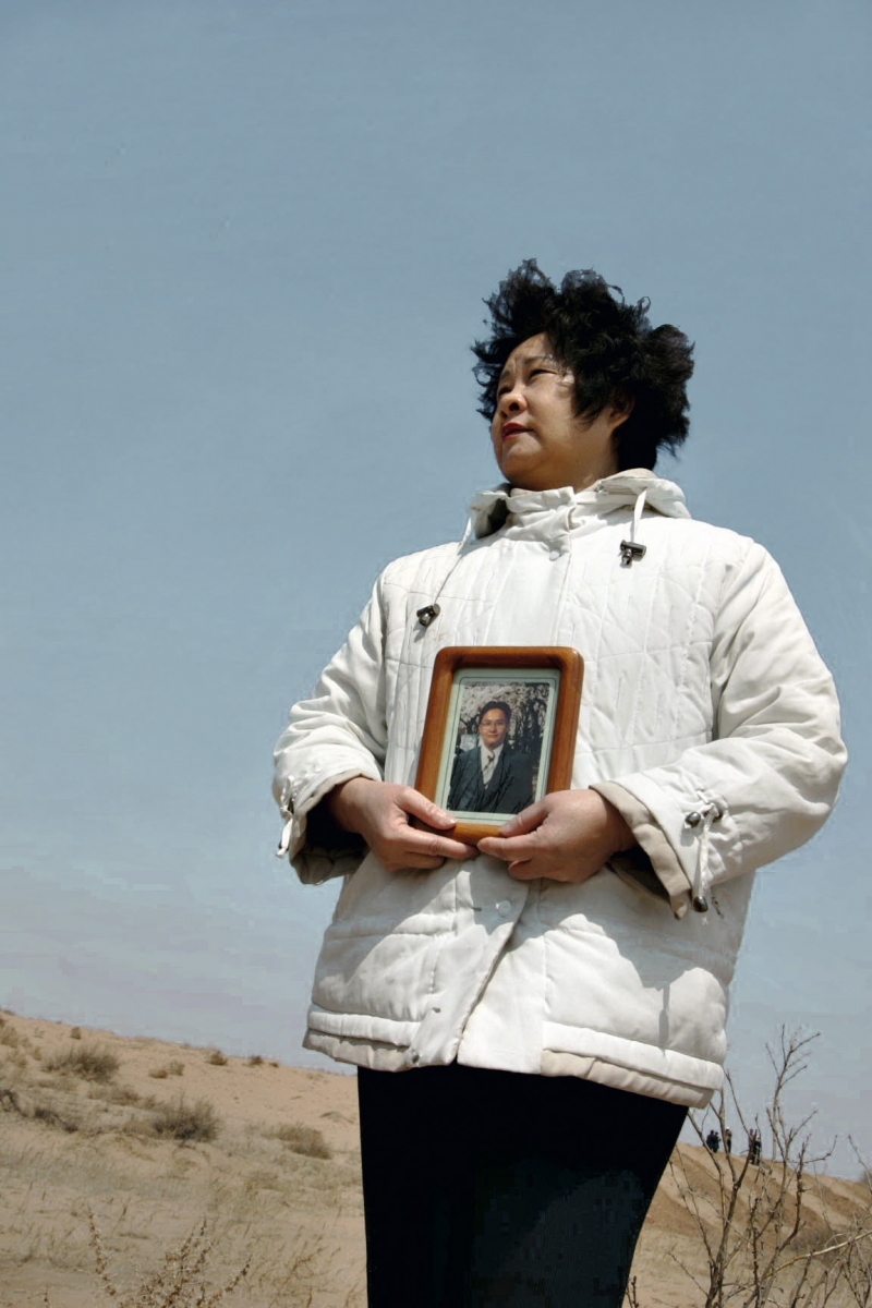 手捧兒子的照片,讓他也能見證荒漠變綠洲的奇跡。